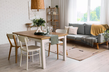 Interior of light room with dining table and sofa