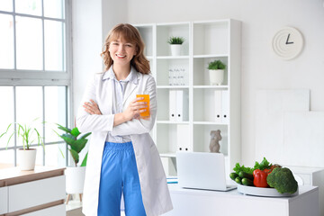 Female nutritionist with glass of juice in office