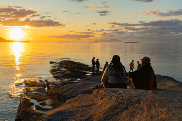 crowd of people watching a sunset at the beach