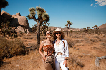Luxury girls in cowboy outfits posing in Joshua tree park, CA