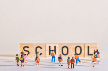 Schoolchildren play in front of the school lettering