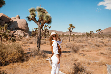 A cute woman dressed in cowgirl style pose in Western Park, Joshua Tree, California