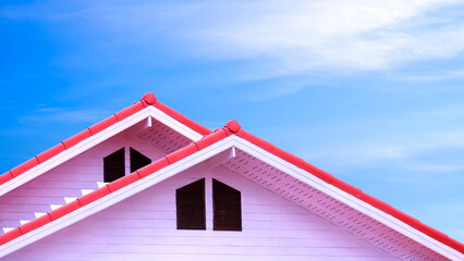 2 different level roofs with red ridge capping tile attic windows of white vintage house against...