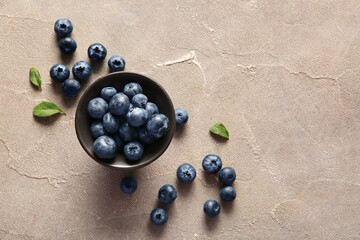 Bowl with fresh ripe blueberry on grunge background
