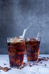 homemade cold brew coffee in glass with iced on white marble floor.