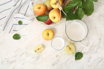 Glass and jug of fresh apple kvass on white background