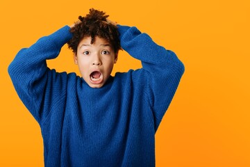 wideeyed young boy with hands on head expressing astonishment and surprise at an unexpected event in childhood moment