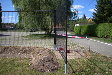 Einbetonieren von selbstgemachten Halterungen für Bauzaunanlage als Festinstallation.