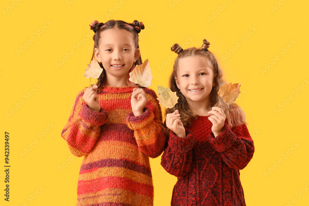 Sticker Cute little happy girls in stylish clothes with autumn leaves on yellow background