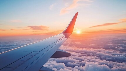 A close-up of an airplane wing against the backdrop of a vibrant sunset, with soft clouds below. Ideal for travel and airline advertisements with copy space.