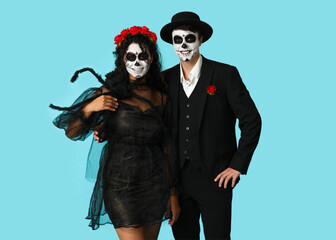 Young couple dressed for Halloween on blue background
