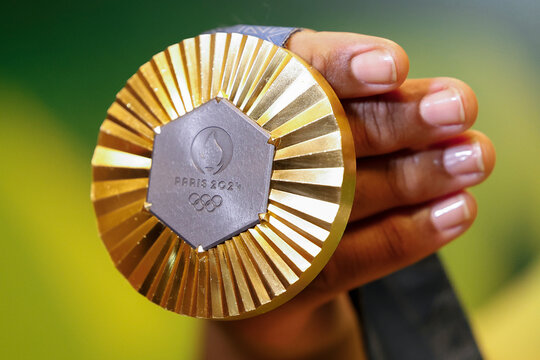 Gold medal of Paris 2024 Olympic Games handheld detail shot, sports competition winner symbol.