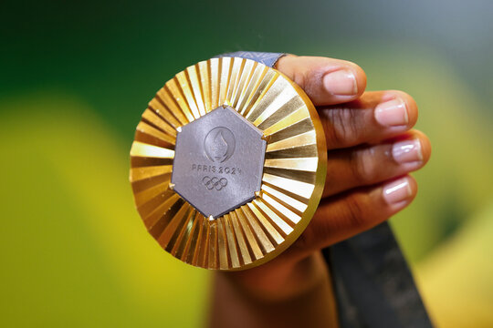 Gold medal of Paris 2024 Olympic Games handheld detail shot, sports competition winner symbol.