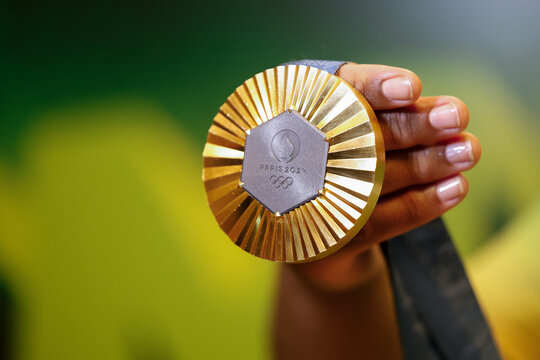 Gold medal of Paris 2024 Olympic Games handheld detail shot, sports competition winner symbol.