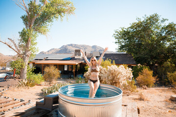 A beautiful blonde bathes in a cowboy bath on vacation. Joshua Tree, California