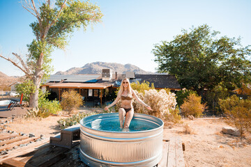 Pretty blonde woman posing in a cowboy bath on vacation. Joshua Tree, California