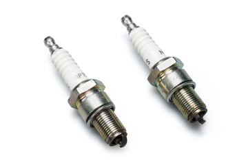 Studio photography of a spark plug with soft shadow isolated on a white background. New automotive spare parts for car internal combustion engines. Close-up automobile component. 
