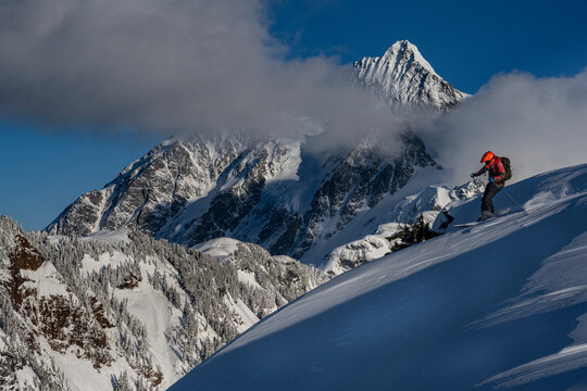 USA, Washington State. Skier enjoying powder with Mount Shuksan in background, Washington State. (MR)