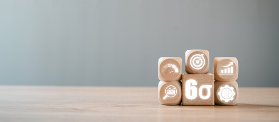 Wooden blocks with business icons illustrating the Six Sigma concept for quality management and process improvement in a professional setting.