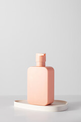 A pink mock-up of a cosmetic product with a place for a logo. Shampoo, gel