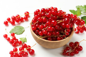 Fresh red currant berries in bowl on white table, closeup