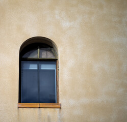 Fototapeta premium Vintage Arched Window on a Faded Yellow Wall.