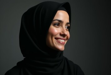 Naklejka premium A woman wearing a black head scarf is smiling