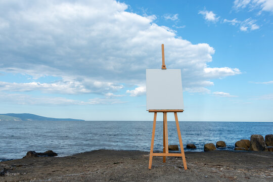 Molbert with empty canvas on the sea shore