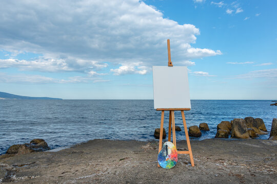 Molbert with empty canvas on the sea shore