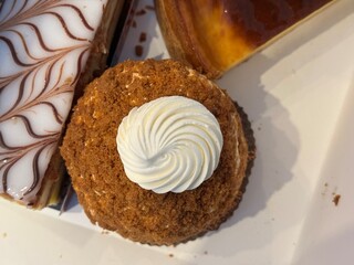 Overhead shot of assorted pastries, including a crumb-coated cream-filled dessert and a Mille-feuille with decorative icing