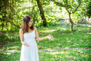 Portrait Asian Woman relaxing in green park. Happy Relax asian woman smiling face at outdoors garden. Young women enjoy nature freedom lifestyle. Greenery wellbeing outside beauty in nature.