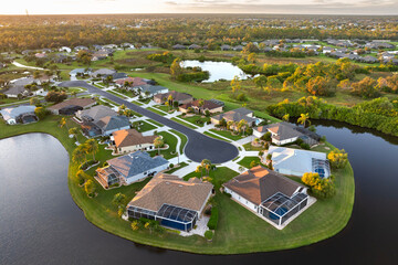 American dream homes at evening on rural cul-de-sac street in US suburbs. View from above of waterfront residential houses in living area in North Port, Florida