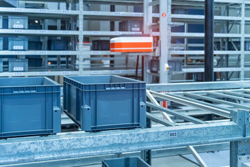 plastic boxes in the cells of the automated warehouse. Metal construction warehouse shelving