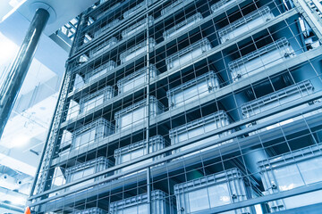 plastic boxes in the cells of the automated warehouse. Metal construction warehouse shelving