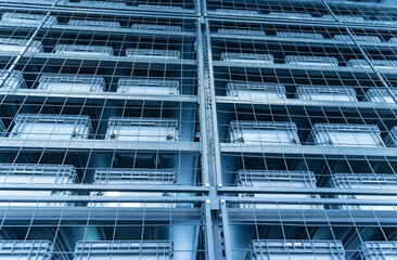 plastic boxes in the cells of the automated warehouse. Metal construction warehouse shelving