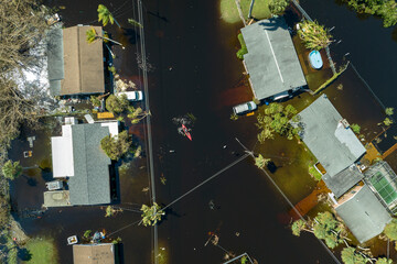 Consequences of natural disaster. Kayak boat floating on flooded street surrounded by hurricane Ian...