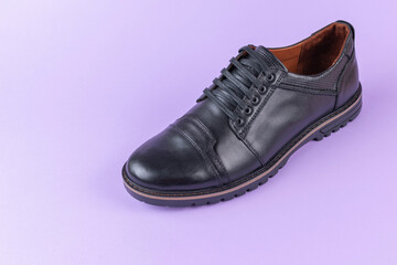 Stylish Black Leather Shoe on Pastel Purple Background – Modern Footwear, Casual Style, Fashion Accessory