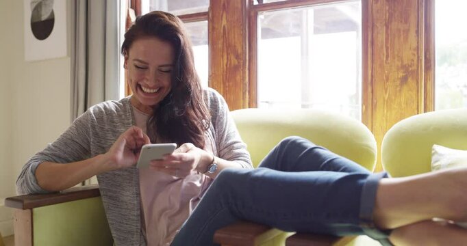 Cellphone, home and laughing woman reading online dating app forum, funny website notification or contact social media user. Comedy, phone and relax person typing, scroll or send meme on lounge chair