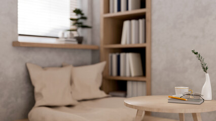 A round wooden table features a book, eyeglasses, and a pencil in a cozy, contemporary room.