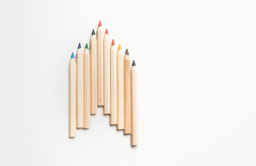 Set of natural wood-colored pencils neatly arranged in a row, showcasing a variety of colors on a clean white background.Ideas for concepts of creativity and art education