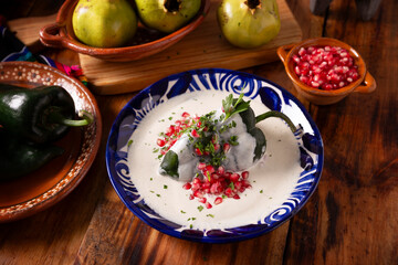 Chiles en Nogada, Typical dish from Mexico. Prepared with poblano chili stuffed with meat and fruits and covered with a walnut sauce, parsley and pomegranate.