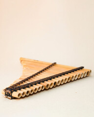Male hands holding a rondador on a beige isolated background. Andean instrument, pan flute, traditional South American instrument.