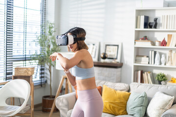 Young woman engaging in virtual reality workout session in living room, She wearing VR headset while performing boxing stance, modern technology with physical fitness, digital fitness trends at home