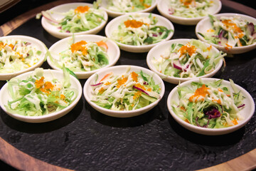 Vegetable salad on small white plated on black table background