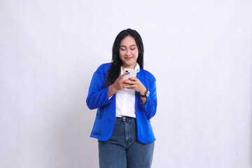 beautiful mature office woman wearing blue formal suit standing candid smile both hands playing with smartphone mobile phone. for technology content, lifestyle, mobile transactions