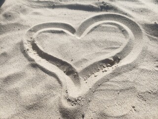 Love message drawn in the sand in the shape of a heart. Heart imprint in the sand. Heart drawn in the sand.