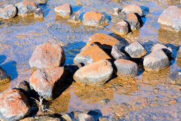 Water flows over the rusty brown rocks at The Silica Rapids