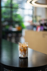 ice latte coffee in plastic glass on black table at cafe​