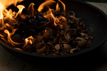Cooking walnut ash in a cast iron pot. Open fire.