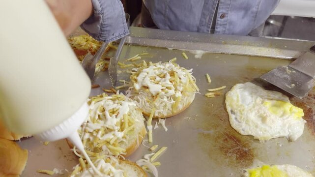 video 4k de preparaci&oacute;n de hamburguesas, colocaci&oacute;n de cremas sobre la ensalada